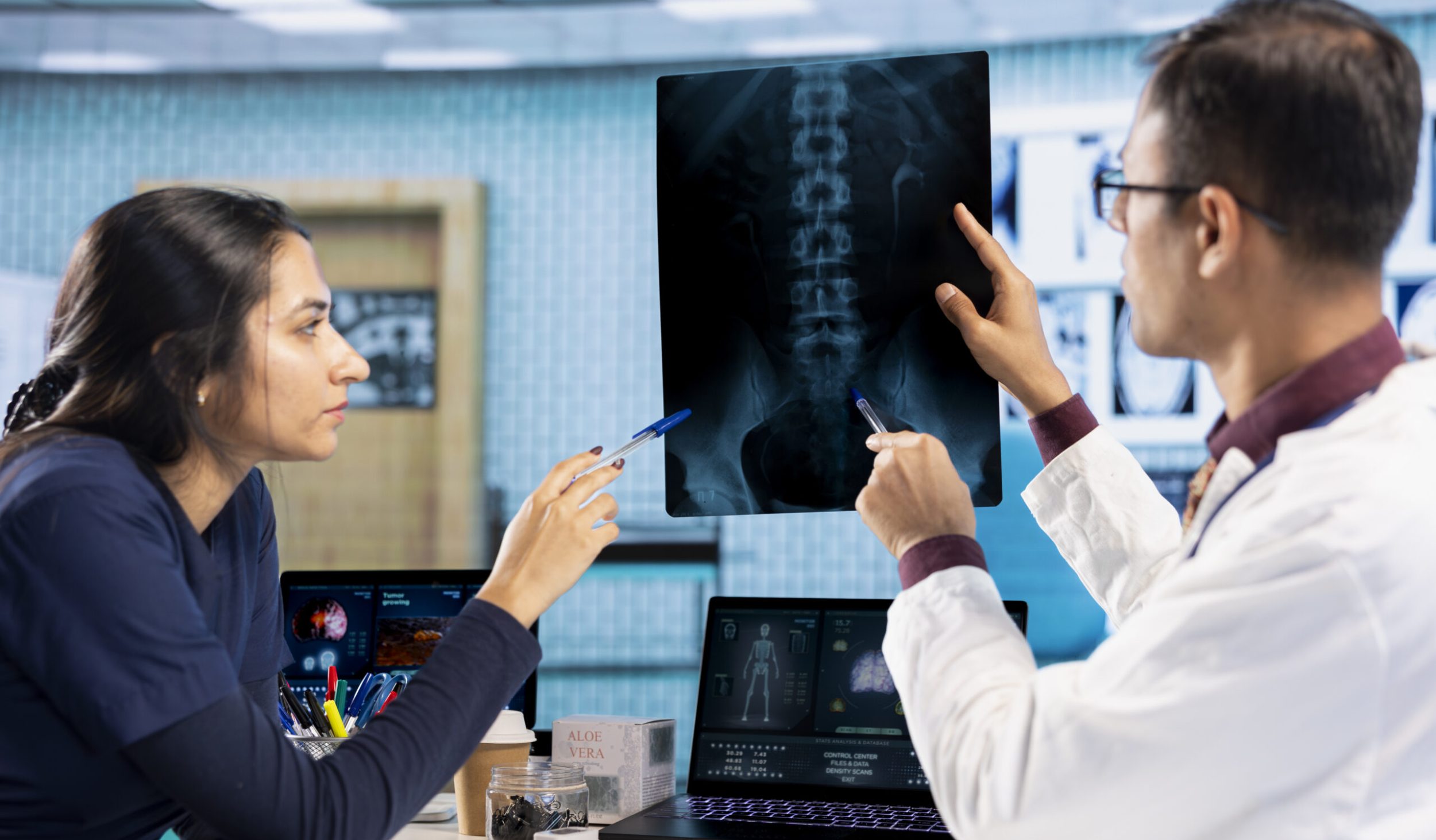 Indian healthcare professional sharing medical expertise with a patient in office, examining x ray and MRI scans results and focusing on disease recovery. Diagnostic report in a meeting.