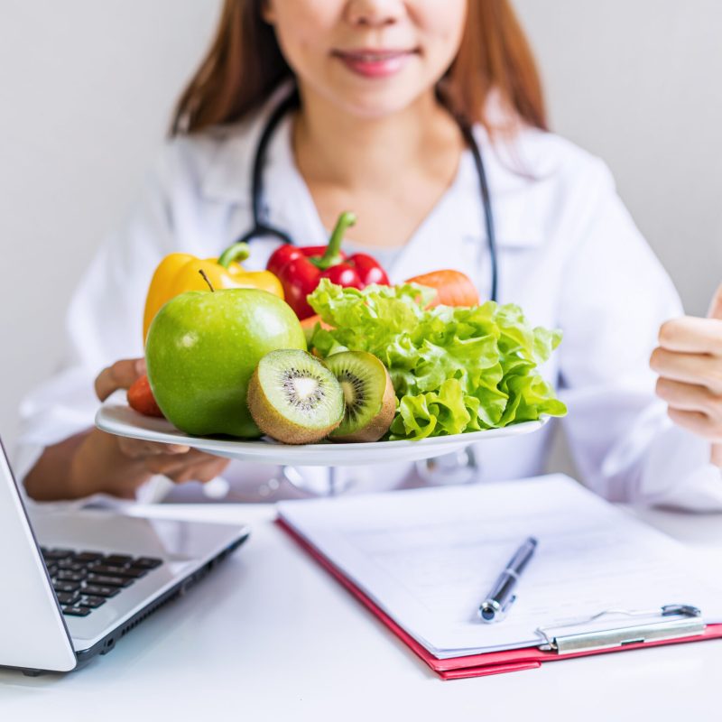 Nutritionist giving consultation to patient with healthy fruit and vegetable, Right nutrition and diet concept